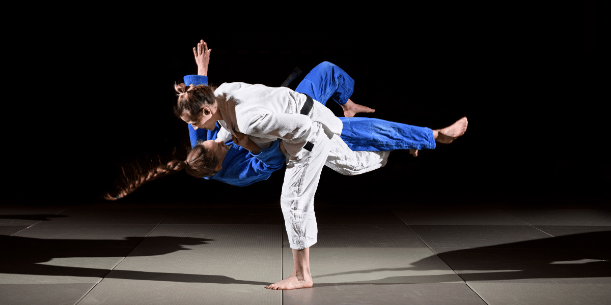 Two people practicing a judo throw
